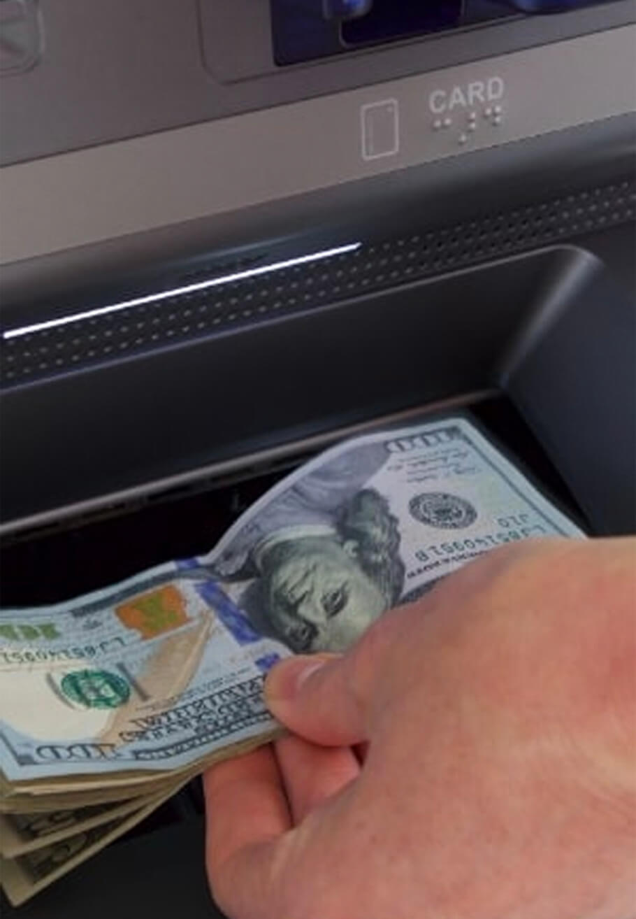 Hand inserting cash at ATM